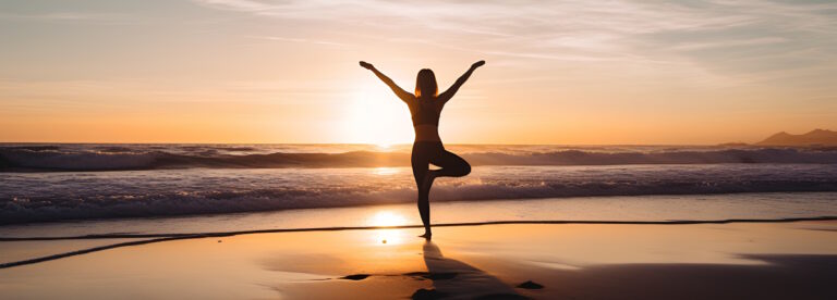 Person practicing yoga on beach during sunset, promoting mental health, self-care, and connection to nature